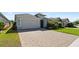 Beautiful single-story home with a well-manicured lawn and a spacious paver driveway leading to a two-car garage at 1925 Estuary Ln, Kissimmee, FL 34747