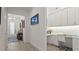 Bright hallway with modern flooring leading to a home office with custom cabinetry and a desk at 1925 Estuary Ln, Kissimmee, FL 34747