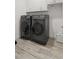 Modern laundry room features front load washer and dryer and bright white cabinets above at 1925 Estuary Ln, Kissimmee, FL 34747