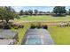 Aerial view of a screened-in pool overlooking a golf course and lush landscaping with an American flag in the yard at 1925 Estuary Ln, Kissimmee, FL 34747