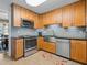 Modern kitchen with stainless steel appliances, light wood cabinets, and a stylish tile backsplash at 210 Lonesome Pine Dr, Longwood, FL 32779