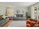 Bright living room with light green walls, a gray sofa, a patterned rug, and a window view of the outdoors at 210 Lonesome Pine Dr, Longwood, FL 32779