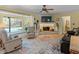 Inviting living room with a stone fireplace, large bay window overlooking the pool, and neutral-toned flooring at 210 Lonesome Pine Dr, Longwood, FL 32779