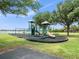 A modern playground with slides, swings, and climbing structures surrounded by green grass at 210 Lonesome Pine Dr, Longwood, FL 32779