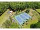Aerial view of three blue tennis courts with green fencing and a nearby picnic pavilion at 210 Lonesome Pine Dr, Longwood, FL 32779