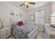 Cozy bedroom featuring a ceiling fan, floral bedding, and a bright window with patterned curtains at 2380 Kaley Ridge Rd, Clermont, FL 34715