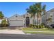 Charming single-story home featuring a well-manicured lawn and a two-car garage with palm trees at 2380 Kaley Ridge Rd, Clermont, FL 34715