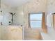 Bathroom with white marble walls, black shower fixtures, and window at 2535 Oneida Loop, Kissimmee, FL 34747