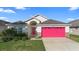 Welcoming single-Gathering home showcasing a bright pink garage door and a well-maintained front yard at 2535 Oneida Loop, Kissimmee, FL 34747