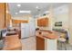 Bright kitchen with wood cabinets, tile flooring, and open layout to the living area at 2535 Oneida Loop, Kissimmee, FL 34747