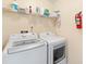 Well-equipped laundry room with washer, dryer, and ample shelving for storage at 2535 Oneida Loop, Kissimmee, FL 34747