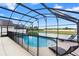 Screened-in pool area with water views, fencing, and relaxing lounge chairs at 2535 Oneida Loop, Kissimmee, FL 34747
