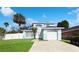 Charming light blue two-story home featuring an attached garage, landscaped yard, and well-manicured lawn at 2601 Spring Hill Dr, Kissimmee, FL 34743