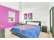 Modern bedroom with purple accent wall, bright window, eclectic art, and comfortable seating at 2618 Calistoga Ave, Kissimmee, FL 34741