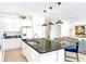 A kitchen with white cabinets and a black granite countertop island with bar stool seating at 2618 Calistoga Ave, Kissimmee, FL 34741
