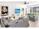 A cozy living room has comfortable gray sofas, a large TV, and a sliding glass door to the lanai at 2618 Calistoga Ave, Kissimmee, FL 34741