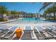 Inviting community pool with lounge chairs, palm trees, and a modern clubhouse nearby at 2618 Calistoga Ave, Kissimmee, FL 34741