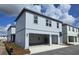 Modern two-story home with two-car garage, gray siding, and ample natural light under blue skies at 2963 Embark Trail, St Cloud, FL 34771
