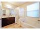 Bathroom with double vanity, bathtub, tiled shower, and large window at 3041 Cardillino Way, Kissimmee, FL 34741