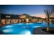 Illuminated community pool and clubhouse at twilight, reflecting in the crystal-clear water with palm tree accents at 3041 Cardillino Way, Kissimmee, FL 34741