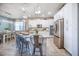 Bright open-concept kitchen with stainless steel appliances, granite counters, island with seating, and modern light fixtures at 3041 Cardillino Way, Kissimmee, FL 34741
