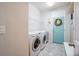 Functional laundry room with modern washer and dryer, plus stylish decor and a bright blue door at 3041 Cardillino Way, Kissimmee, FL 34741