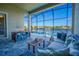 A screened-in patio features blue chairs, a dining table, and a lake view with pool access at 3041 Cardillino Way, Kissimmee, FL 34741