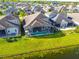 Aerial view of a home's backyard featuring a screened pool and lush green lawn extending to the water's edge at 3041 Cardillino Way, Kissimmee, FL 34741