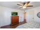 Bedroom features wood floors, ceiling fan and TV at 30746 Fairview Ave, Tavares, FL 32778