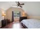 Vaulted bedroom features a ceiling fan, hardwood floors, and a large window at 30746 Fairview Ave, Tavares, FL 32778