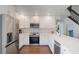 Modern kitchen features white cabinetry, stainless steel appliances, and hardwood floor at 30746 Fairview Ave, Tavares, FL 32778