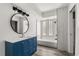 Modern bathroom with a blue vanity and a large round mirror at 3137 East St, Oviedo, FL 32765