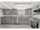 Renovated kitchen boasts gray cabinets, granite counters, stainless appliances, and tile flooring at 3137 East St, Oviedo, FL 32765