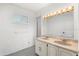 Simple bathroom with a double sink vanity, large mirror with light fixture, and a window at 3216 John Anderson Dr, Ormond Beach, FL 32176