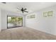 A bedroom includes balcony access, a ceiling fan, and two large windows at 3216 John Anderson Dr, Ormond Beach, FL 32176