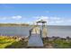 Dock with a covered sitting area extends over the water, providing a tranquil waterfront experience at 3216 John Anderson Dr, Ormond Beach, FL 32176