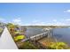 Waterfront views from the home of a dock with a covered sitting area and surrounding palm trees at 3216 John Anderson Dr, Ormond Beach, FL 32176