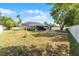 Backyard showcasing solar panels, a covered patio area, and ample green space at 4705 Beggs Rd, Orlando, FL 32810