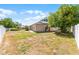 Spacious backyard with well-maintained lawn and home exterior featuring solar panels on the roof at 4705 Beggs Rd, Orlando, FL 32810