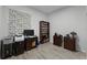 Well-lit bedroom featuring gray wood floors, a bookcase, and office setup with desk and lamp at 4705 Beggs Rd, Orlando, FL 32810