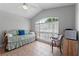 Bright bedroom features tiled floor, day bed, chair, ceiling fan and large window at 4705 Beggs Rd, Orlando, FL 32810