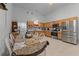 Well-lit kitchen with wooden cabinets, stainless steel appliances, and a dining table with chairs at 4705 Beggs Rd, Orlando, FL 32810