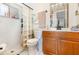 Bright bathroom featuring a glass block shower, vanity with wood cabinets, and white tile flooring at 4723 Cherokee Rose Dr, Orlando, FL 32808