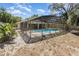 Backyard view of a screened in pool and lush landscaping at 4723 Cherokee Rose Dr, Orlando, FL 32808