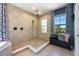 Bathroom with glass shower, tile surround, and black wood bench seat by the window at 4932 Eastlake Vista Dr, St Cloud, FL 34771