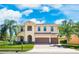 Stunning two-story home with a tile roof, paver driveway, palm trees, and lush landscaping at 4932 Eastlake Vista Dr, St Cloud, FL 34771