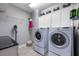 Well-equipped laundry room with modern washer, dryer, cabinets and shelving for organized storage at 4932 Eastlake Vista Dr, St Cloud, FL 34771
