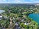 Serene aerial shot showcases homes with pools nestled among mature trees near a stunning lake at 511 Woodlawn Blvd, Orlando, FL 32801