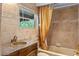 Cozy bathroom featuring decorative tilework, vanity with storage, and a shower with gold-colored curtain at 511 Woodlawn Blvd, Orlando, FL 32801