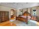 Comfortable bedroom featuring an ornate four-poster bed and hardwood floors at 511 Woodlawn Blvd, Orlando, FL 32801